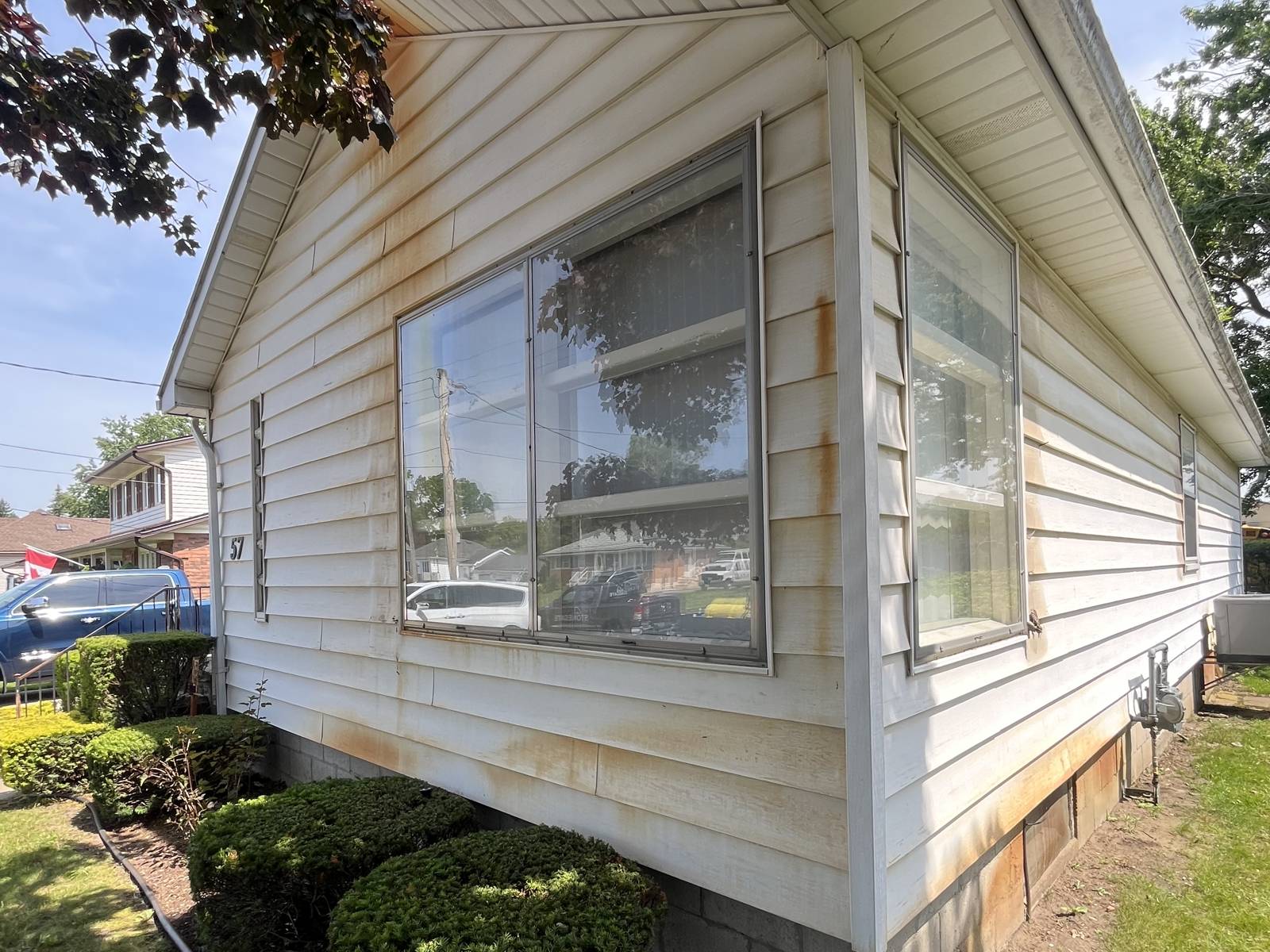 The same siding covered in heavy rust and oxidation stains before cleaning